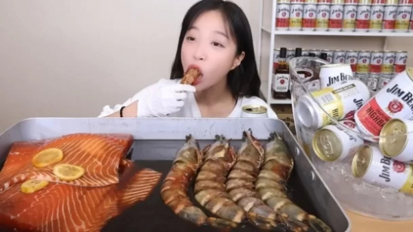 인기 먹방 유투브 쯔양의 한 장면, 뒤로 협찬받은 일본산 주류가 보인다