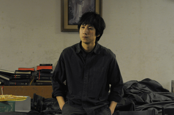 교회 부설 공부방에서 아이들을 가르치는 이선균 뒤로 성경책이 쌓여 있다.