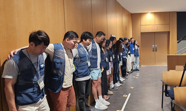 코스타의 상징, 파란 조끼 입은 자원봉사자들이 폐회예배에서 어깨동무하며 기도하고 있다. @ 미주뉴스앤조이