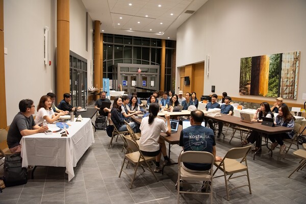 컨퍼런스 시작에 앞서 간사 회의을 진행하고 있다. @ 사진 강동인 간사 (미주코스타 / KOSTA USA). 미주코스타는 매년 대회 종료 후 간사들이 모여 설문에 응답한 자료를 참고하여 다음 대회 주제를 선정한다. 시대적 흐름과 청년 세대의 현실을 반영한 신학적 숙고를 바탕으로 선정된 주제는 목회자와 평신도가 함께하는 공동대표단의 검토를 거쳐 최종 확정된다. 강사 선정 역시 간사들이 중심이 되어 각 강사의 메시지와 신학적 방향을 직접 듣고 평가한 뒤 결정한다. 이는 단순한 유명인 초청이 아니라, 하나님 나라 신학에 기반한 균형 잡힌 구성을 지향한다. 