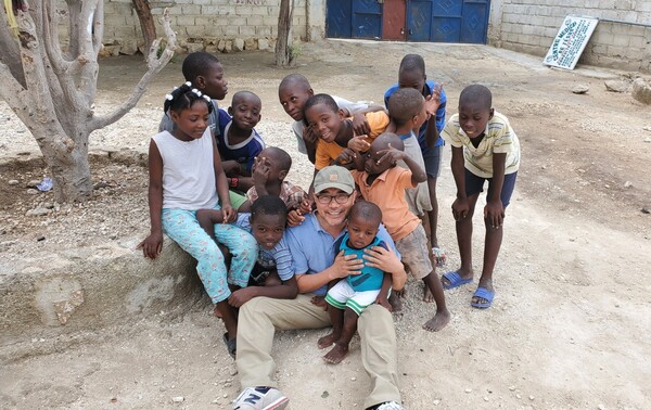 고아원에서 자라 그 그림자를 안고 살아온 조원태 목사. 그러나 그 기억은 무겁게 짓누른 것이 아니라 오히려 더 깊은 측은지심으로 이끌었습니다. 조목사는 오래전부터 아이티의 고아원을 정기적으로 찾아가 손을 잡아주며 희망을 말해주고있다. 또 뉴욕우리교회 부임 후 첫 외부 일정을 장애인 기관 방문이었다는 그의 발걸음처럼 약한 자들을 향한 마음은 늘 그의 사역의 출발점이었습니다. 사진은 아이티 고아원에서 아이들과 나란히 앉아 환하게 웃는  조목사.